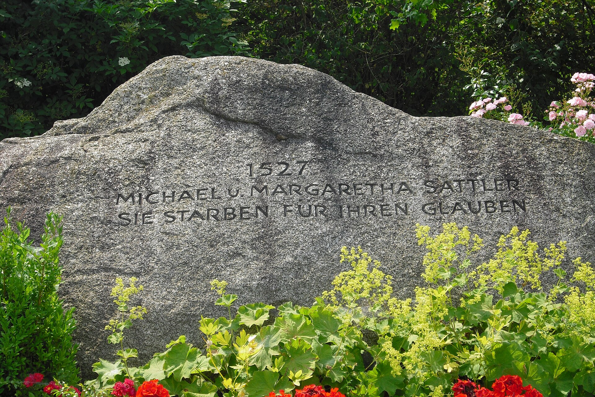An upright memorial stone with a carved inscription standing in grass at Rottenburg am Neckar