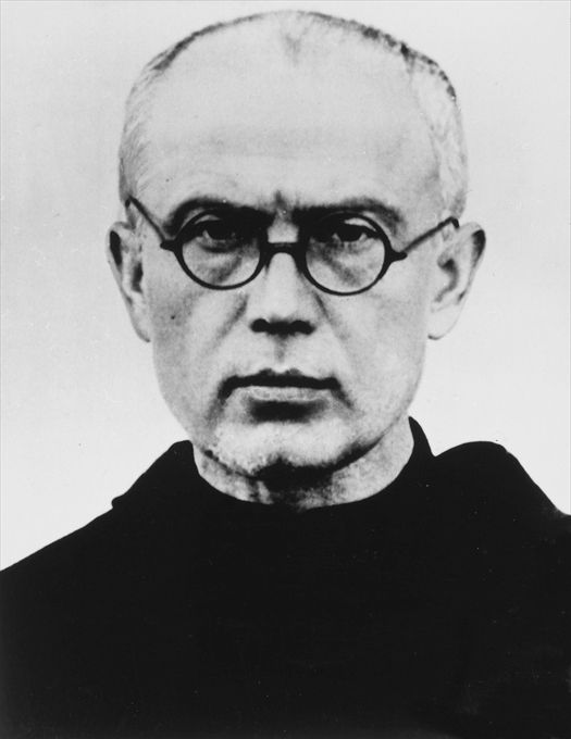 Black and white photograph of a bespectacled man with a beard in a dark religious habit, facing the camera