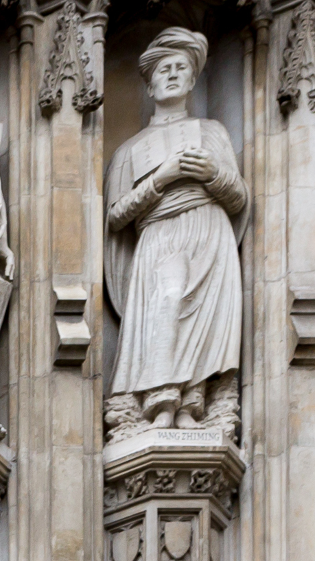 Stone statue of a man in a long robe standing in a niche on the west front of Westminster Abbey