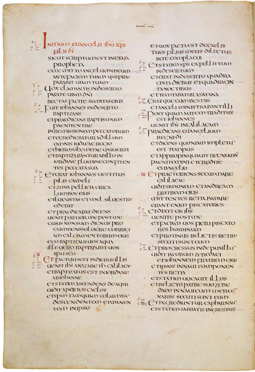 Manuscript page in two columns of large, regular capital letters in brown ink, with a few lines in red at the head of the first column
