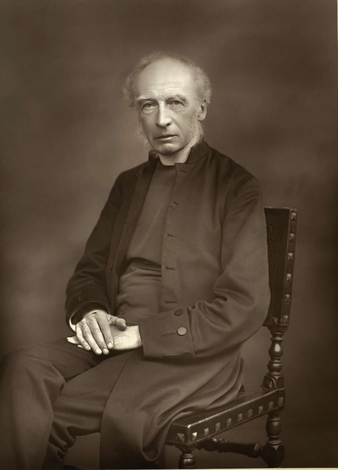 Black and white photographic portrait of an elderly bearded clergyman in a bishop's dress, seated, facing slightly to the left