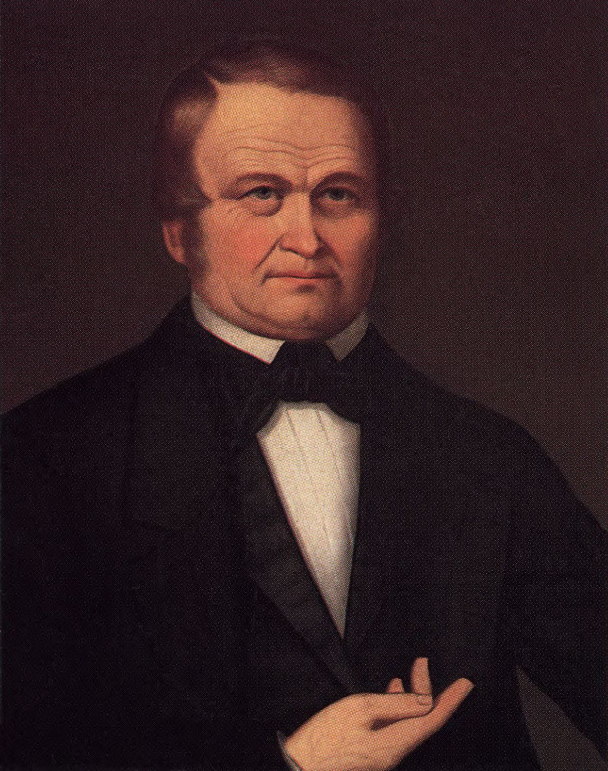Full-length painted portrait of an older man in a dark coat standing beside a table with a book, against a plain background