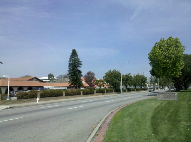 Exterior of the main sanctuary of Calvary Chapel Costa Mesa beside a sign welcoming drivers to Santa Ana