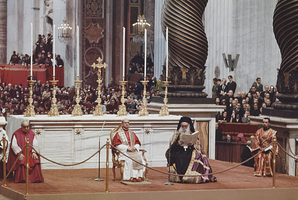 Black and white photograph of two elderly churchmen side by side at a ceremony, one with a long white beard and a tall dark headdress, the other in papal white vestments