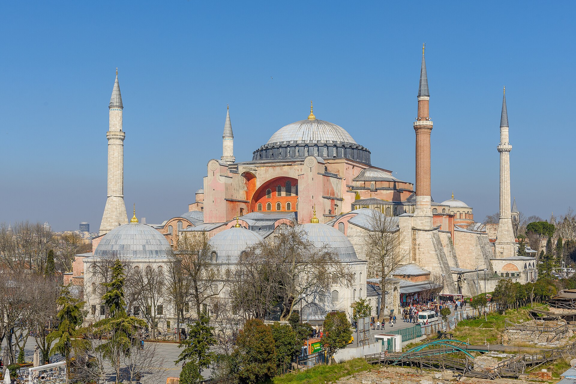 The great domed building of Hagia Sophia in Istanbul under a clear sky, with four tall minarets at its corners and lower domes and buttresses around the central dome
