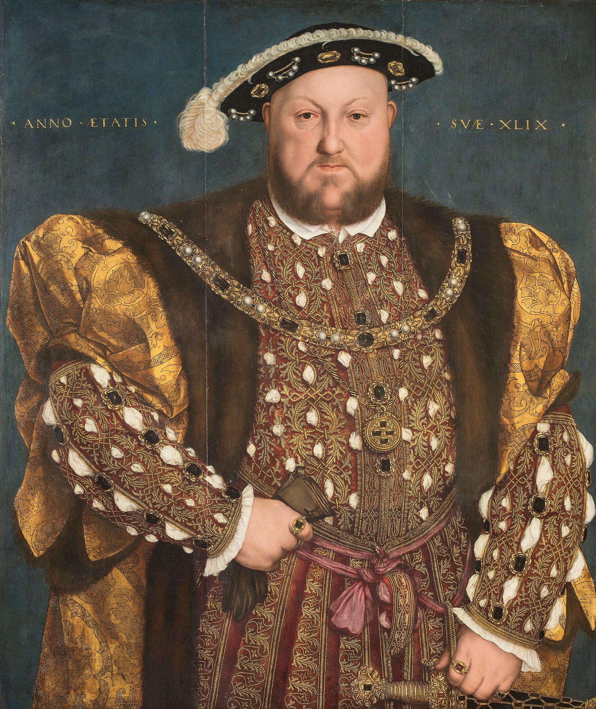 Painted portrait of a broad-shouldered bearded king in a jeweled black cap and a richly embroidered gold and red doublet, against a blue background