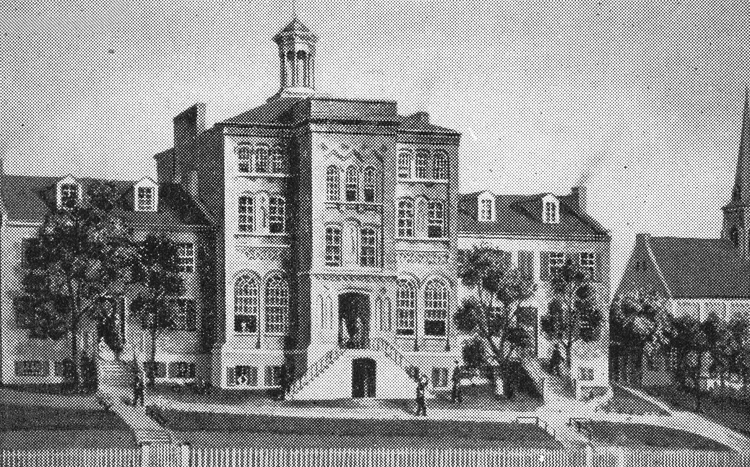 Engraving of a three-story brick building with a central tower and a fenced yard in front