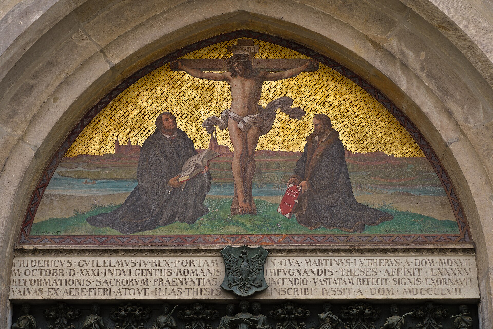 Painted figures in the arched stone tympanum above the doorway of the Castle Church in Wittenberg, under a carved Gothic frame
