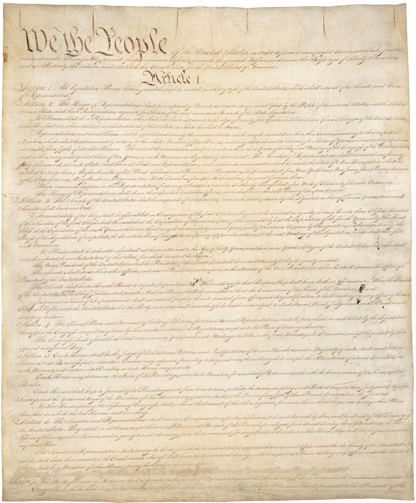 First page of the engrossed Constitution in large brown script on parchment, beginning with the words We the People