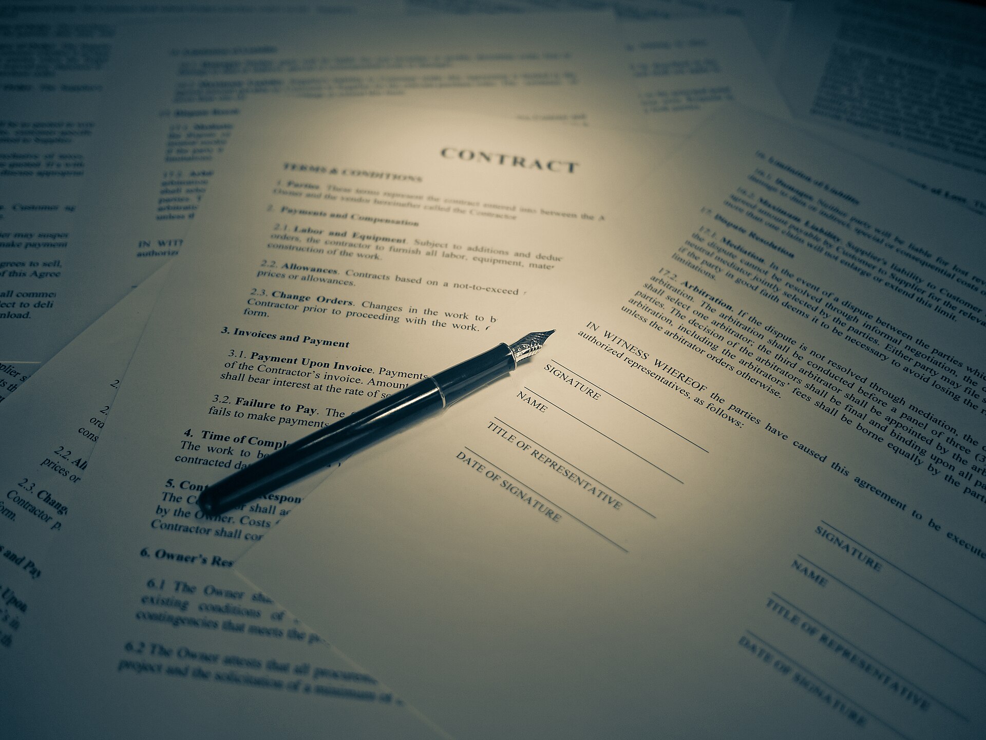 A legal contract and a signature, photographed in warm tones