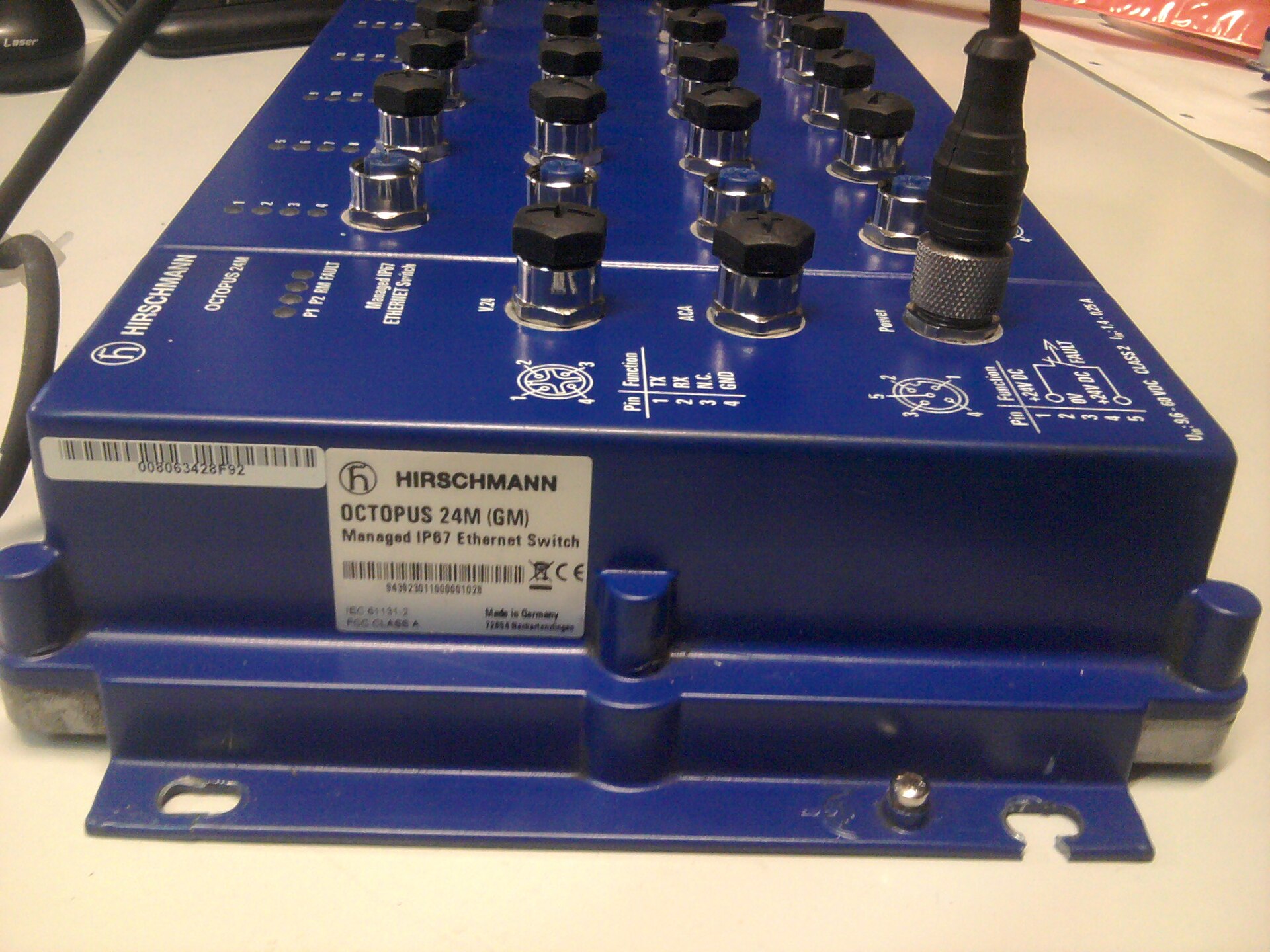 A 24-port managed industrial Ethernet switch with sealed round screw-on cable connectors instead of ordinary plug-in network jacks.