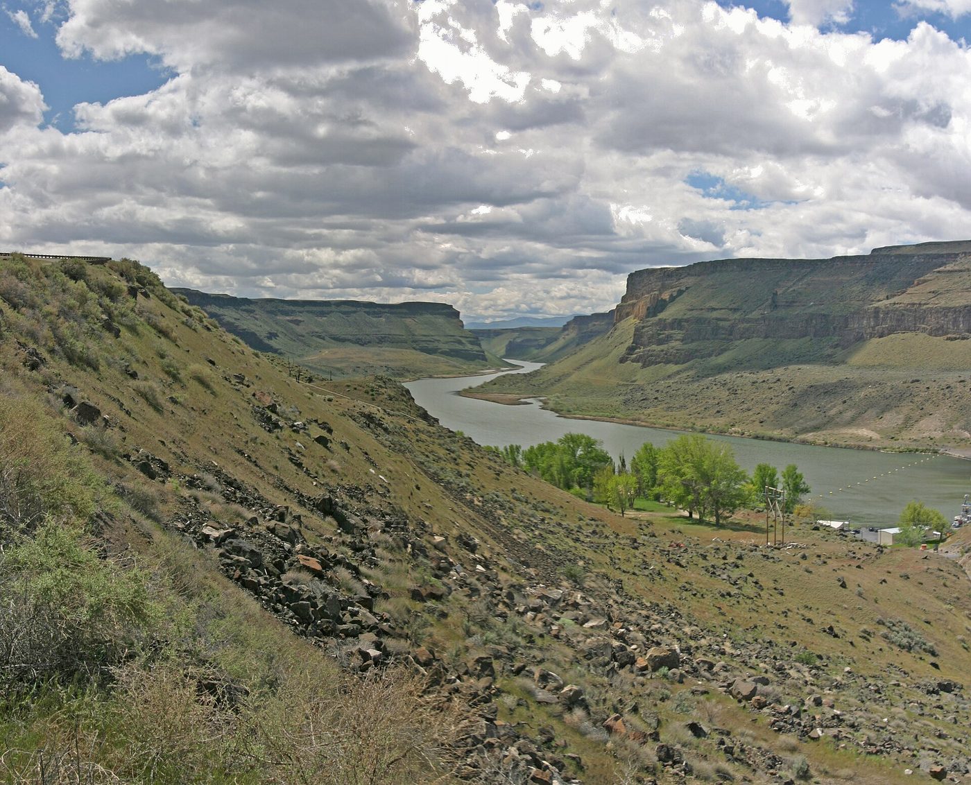 A dam and powerhouse across the Snake River in a rocky canyon