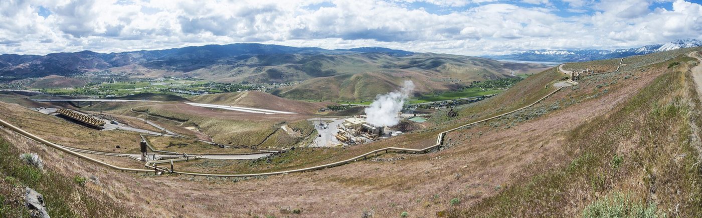 Wide view of the Steamboat Hills and Galena II geothermal power plants, low industrial buildings and pipelines in a high desert valley