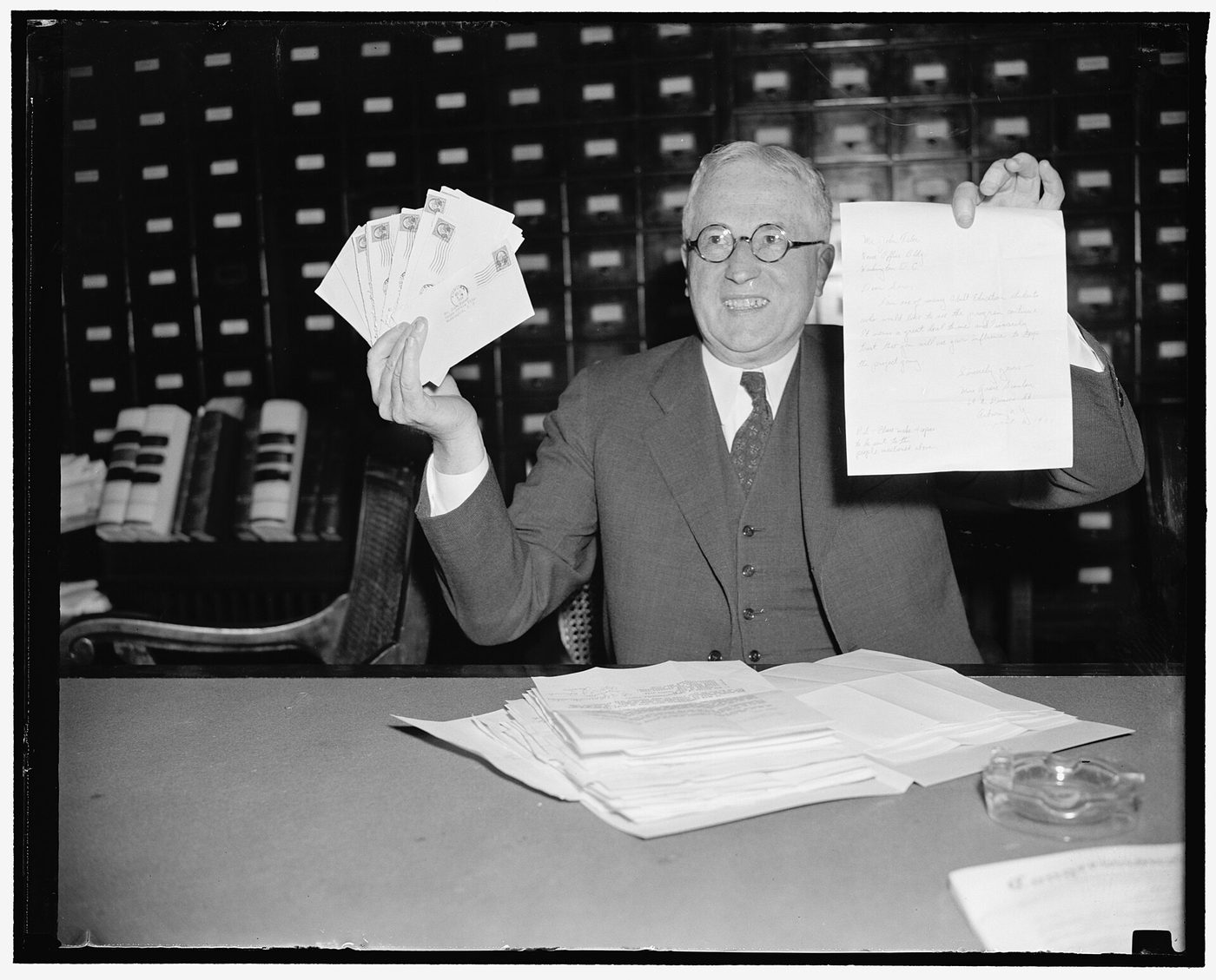 1938 photograph of Rep. John Taber displaying a batch of letters received in the morning mail