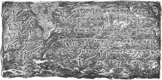 A stone slab with six lines of old Hebrew script, the letters cut into the rock