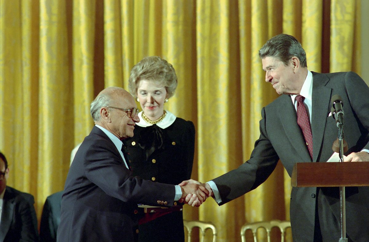 President Reagan shaking hands with Milton Friedman in the East Room of the White House as Friedman receives the Presidential Medal of Freedom