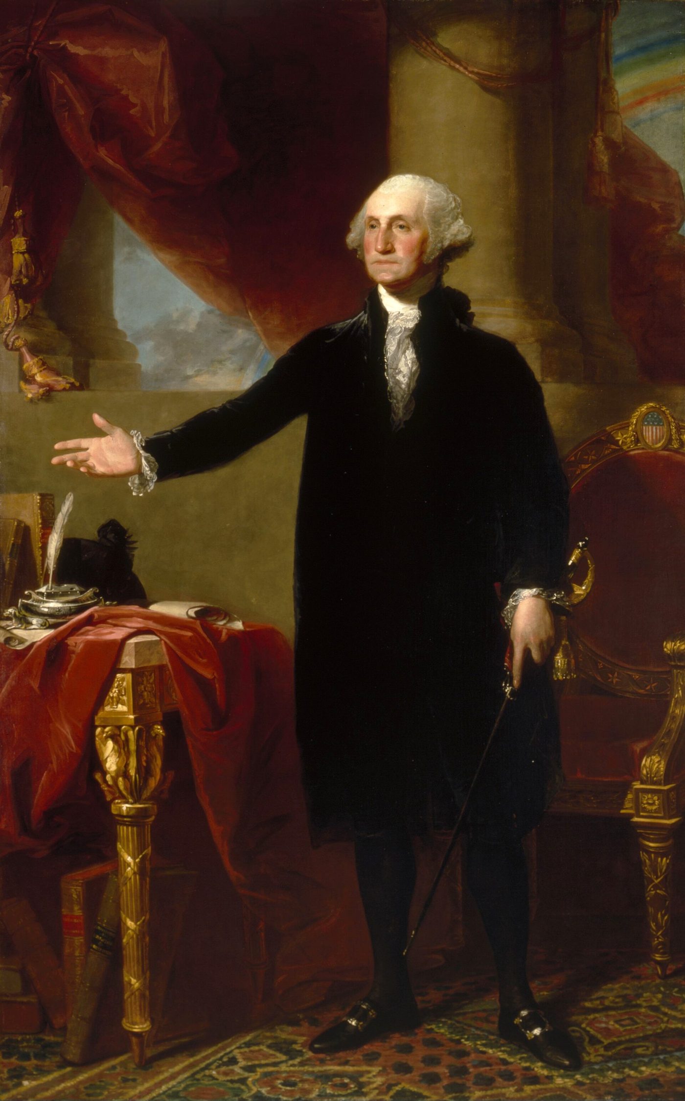 Full-length portrait of George Washington in a black suit, standing with his right arm extended, a sword at his side, beside a table with books and papers, with columns and a red curtain behind