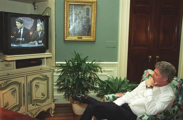 President Bill Clinton watching a television set in the White House showing Vice President Al Gore and Ross Perot debating