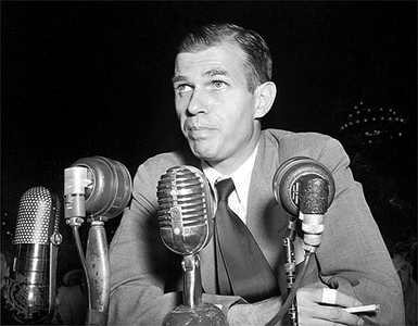 Black and white head and shoulders photograph of Alger Hiss in a suit and tie