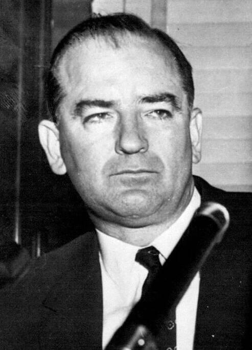 Black and white wire photograph of Senator Joseph McCarthy in a suit and tie, seated, looking to one side