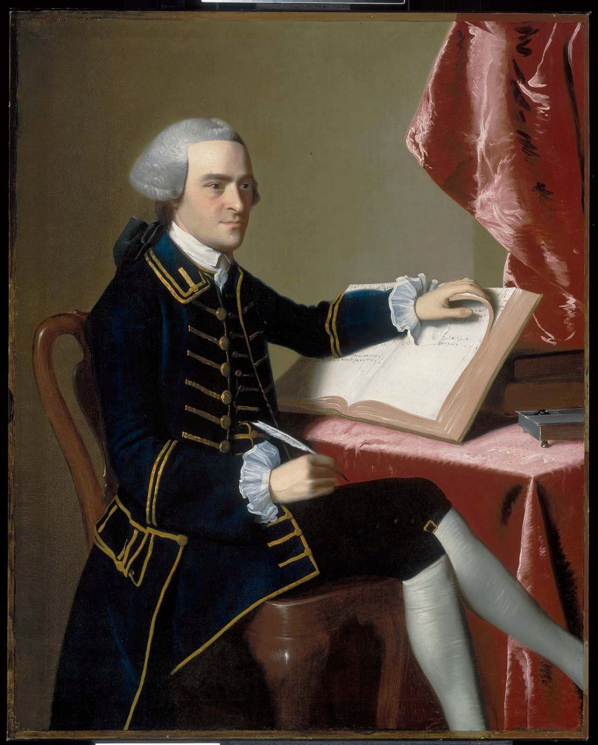 Painted portrait of John Hancock seated at a table covered in red cloth, wearing a dark blue coat with gold trim and a gray wig, holding a quill pen with his left hand on an open ledger
