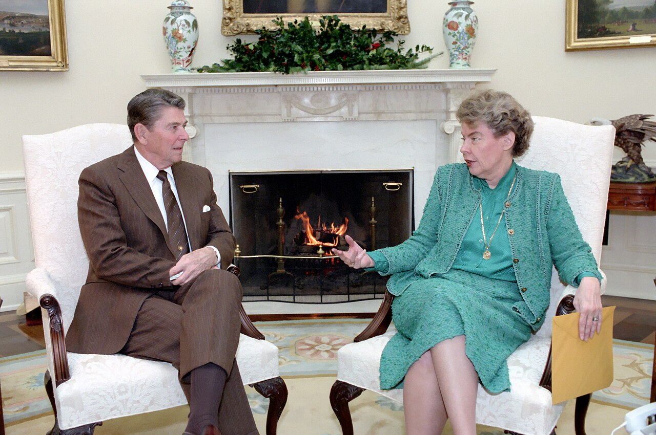 President Ronald Reagan seated in the Oval Office speaking with Jeane Kirkpatrick, who sits across from him
