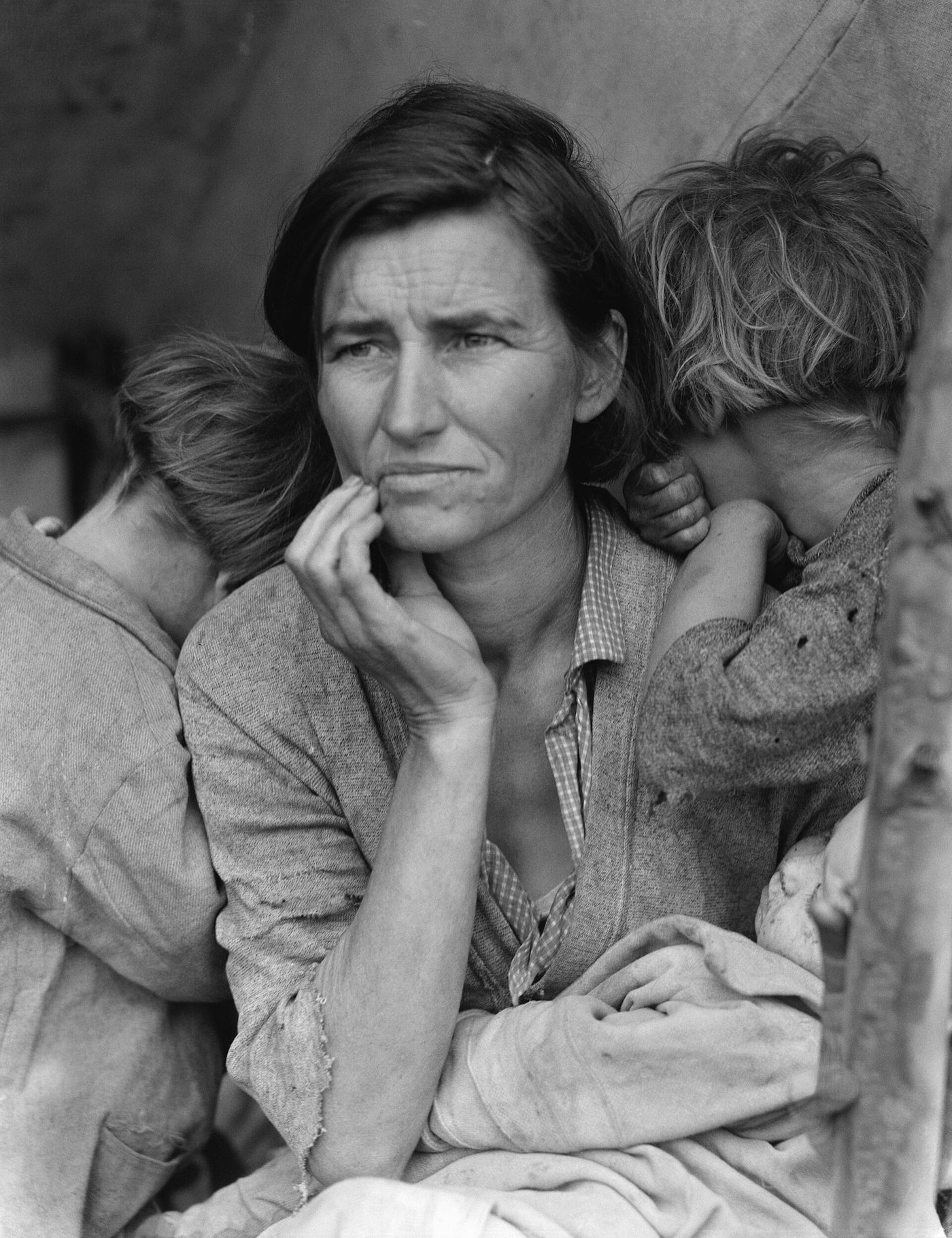 Black and white photograph of Florence Thompson, a worried woman with her hand at her chin, with two children leaning on her shoulders